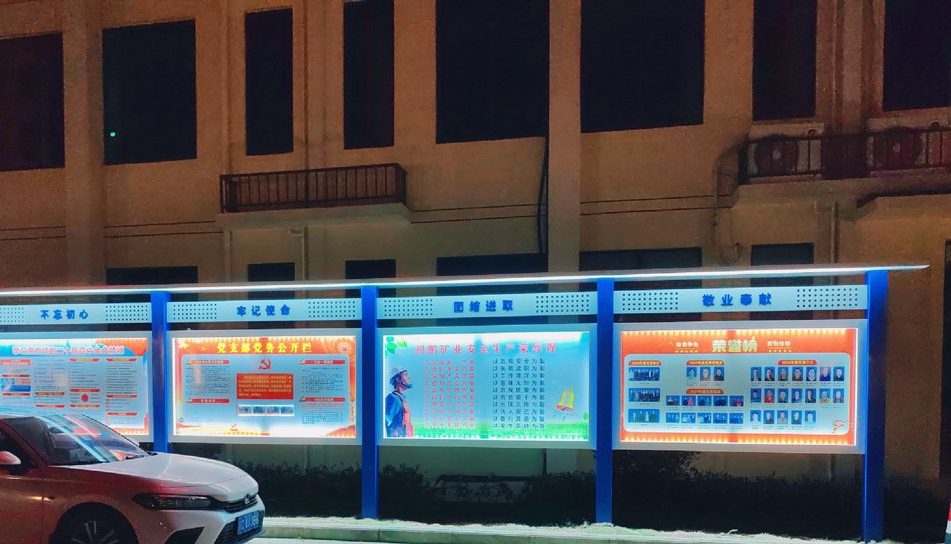 夜里亮着的厂区荣誉榜宣传栏:灯是亮的,位置对不对,得站远一点看。