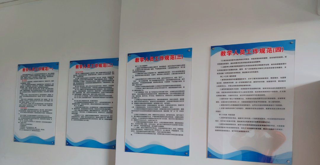同一套版式做出的四块制度牌，挂进培训学校的走廊。
