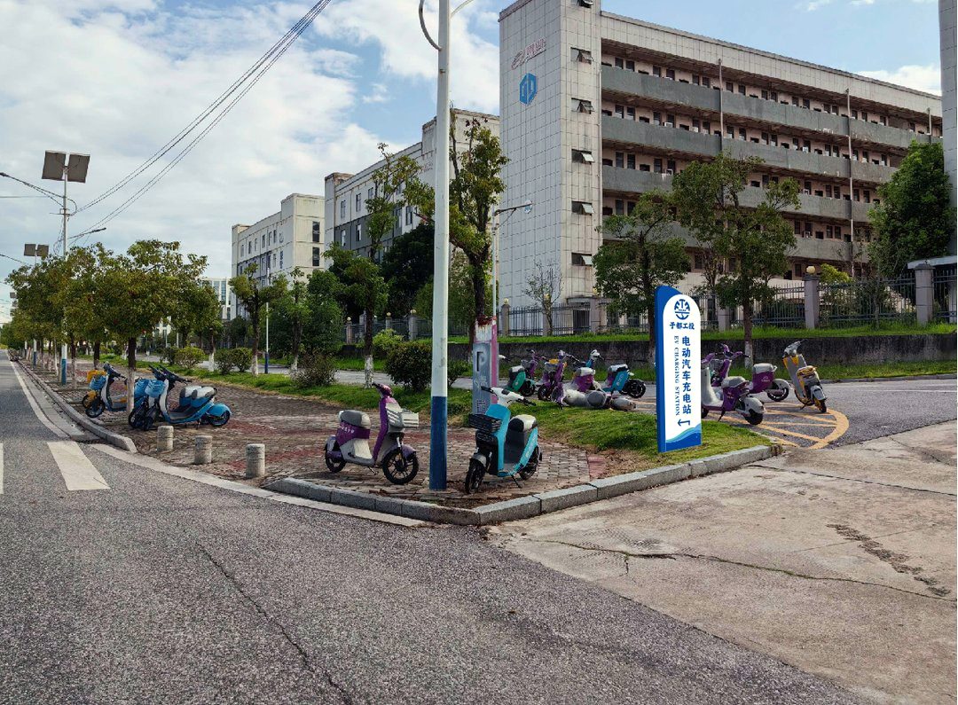 园区里的指引立牌:蓝底白字加箭头,充电车进来不用问人。