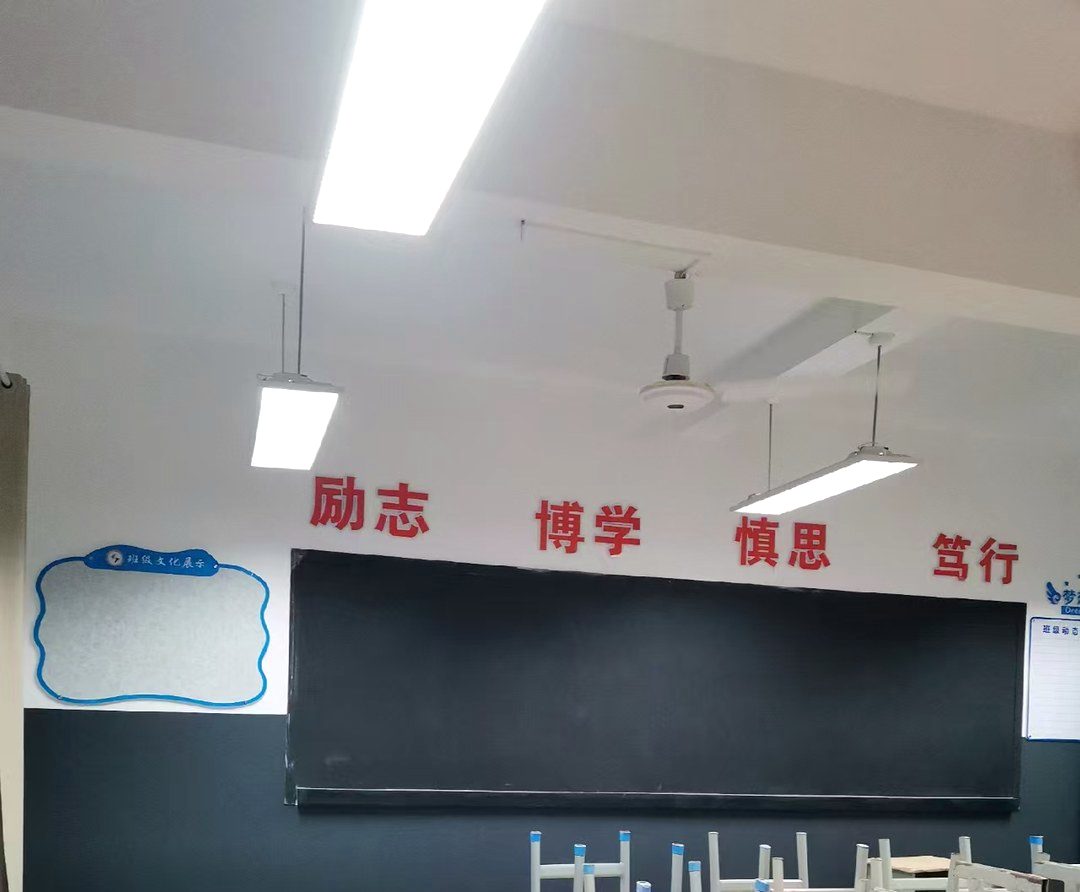 教室前墙全景：一行大字定调，旁边留一块能换的软木板。